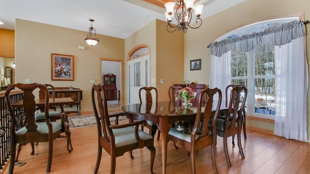 dining area with a chandelier, light wood finished floors, and baseboards