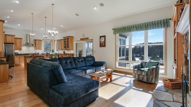 living room featuring an inviting chandelier, light wood-style flooring, vaulted ceiling, and recessed lighting