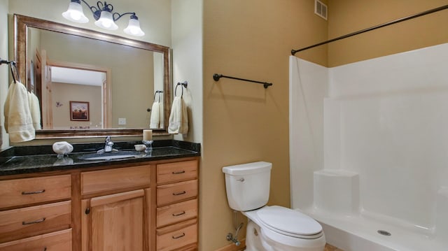 bathroom featuring toilet, a shower, vanity, and visible vents