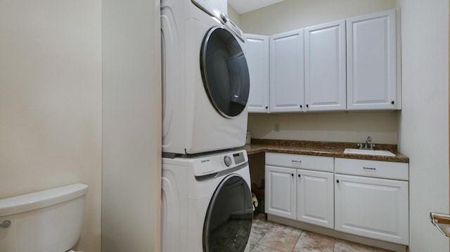 washroom featuring a sink and stacked washer / dryer