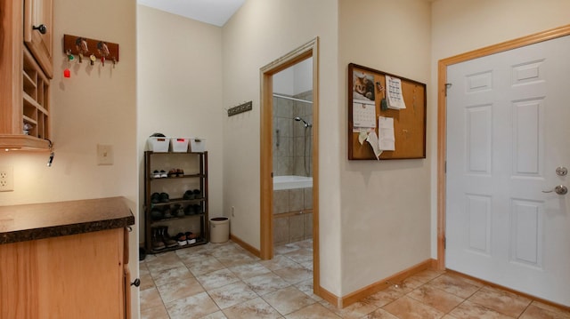 foyer featuring baseboards and light tile patterned floors