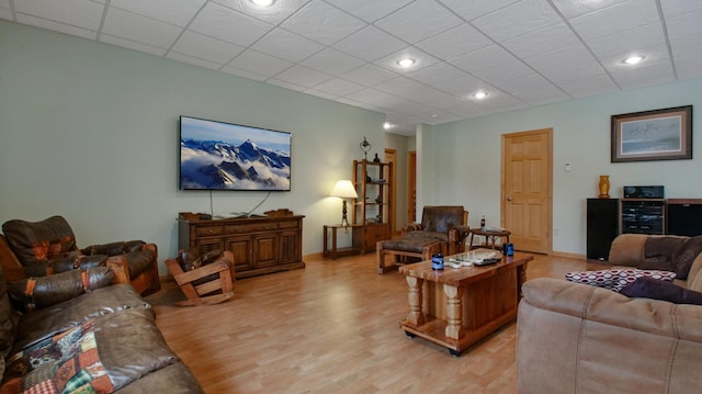 living area with a paneled ceiling, light wood-style flooring, and recessed lighting