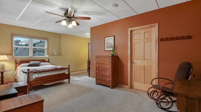 bedroom featuring baseboards, a paneled ceiling, and light colored carpet