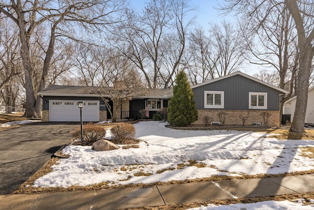 view of front of property featuring brick siding, driveway, and an attached garage