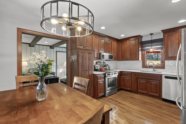 kitchen featuring a sink, light countertops, light wood-style flooring, and stainless steel appliances