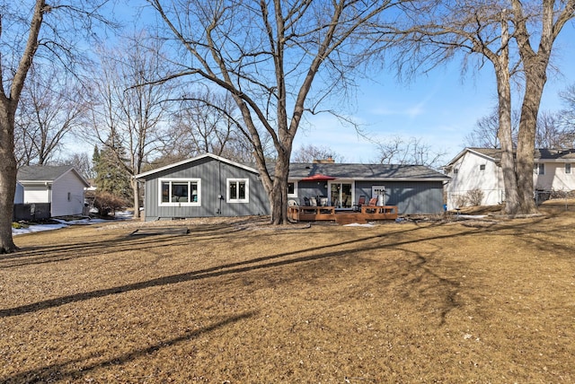 ranch-style home with a deck and a front yard