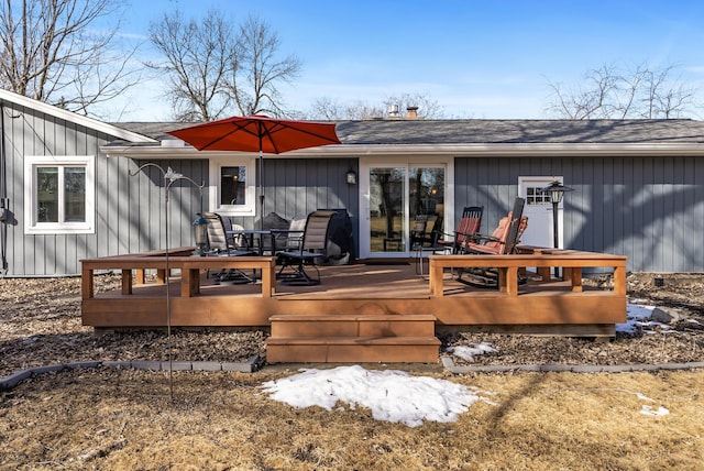 rear view of property featuring a deck and a shingled roof