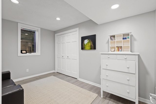 living area featuring recessed lighting, baseboards, and light wood-type flooring