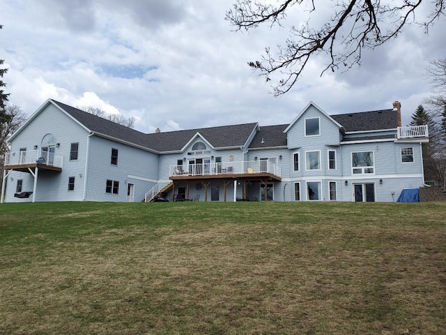 rear view of house featuring a wooden deck, a chimney, and a yard