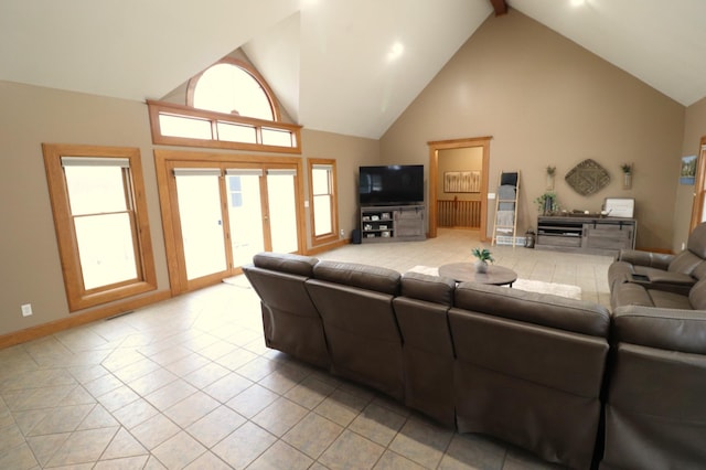 living area with light tile patterned floors, baseboards, high vaulted ceiling, and beam ceiling