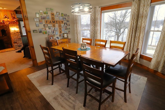 dining room with a notable chandelier, plenty of natural light, and wood finished floors