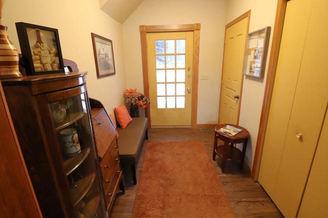 doorway to outside with lofted ceiling and wood finished floors