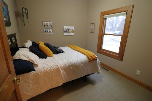 carpeted bedroom with visible vents and baseboards