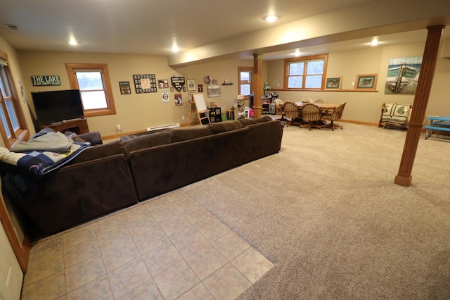 carpeted living room with tile patterned flooring, baseboards, visible vents, and ornate columns