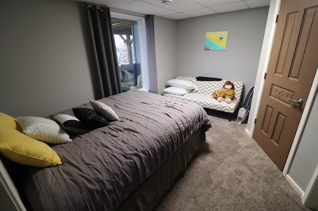 bedroom featuring baseboards, carpet flooring, and a drop ceiling