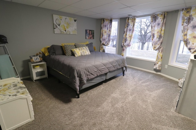 bedroom featuring carpet flooring, a paneled ceiling, and baseboards