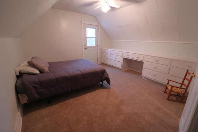 bedroom featuring light carpet, ceiling fan, built in desk, and vaulted ceiling