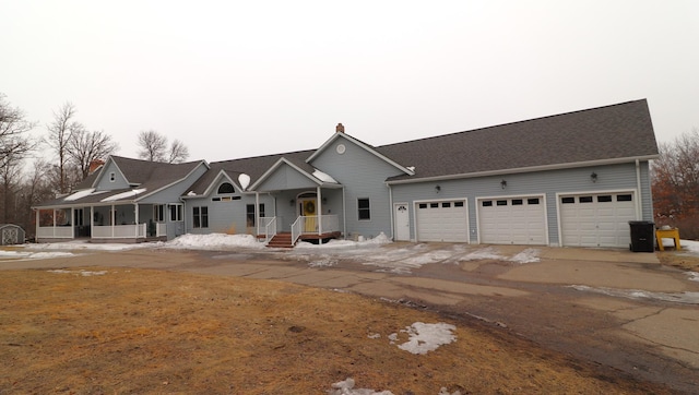 view of front of home featuring dirt driveway and an attached garage