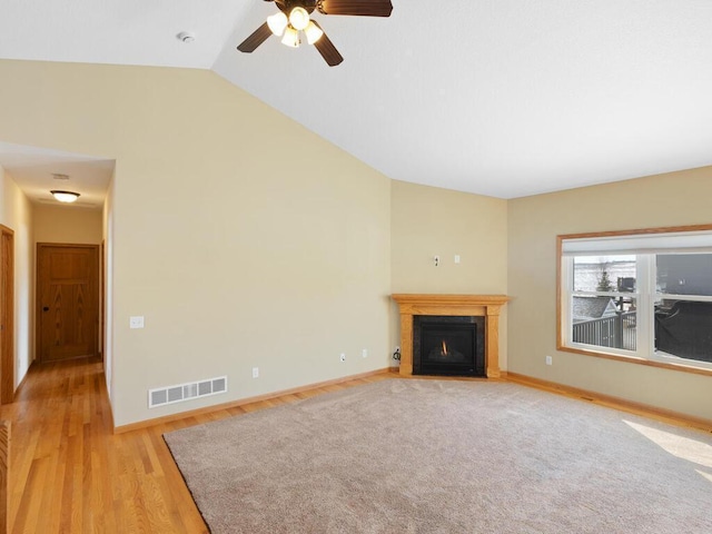 unfurnished living room featuring lofted ceiling, a fireplace with flush hearth, baseboards, and visible vents