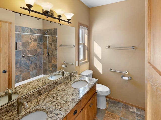 full bath featuring a tile shower, double vanity, toilet, and a sink