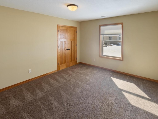 spare room featuring baseboards and carpet floors