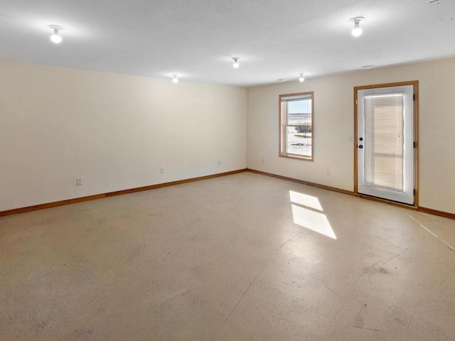 spare room with finished concrete floors and baseboards