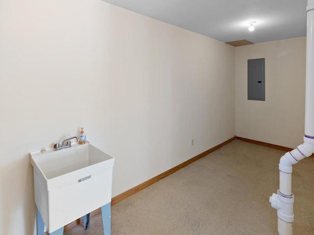 empty room with electric panel, baseboards, and a sink