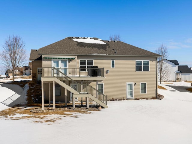 snow covered house featuring stairway