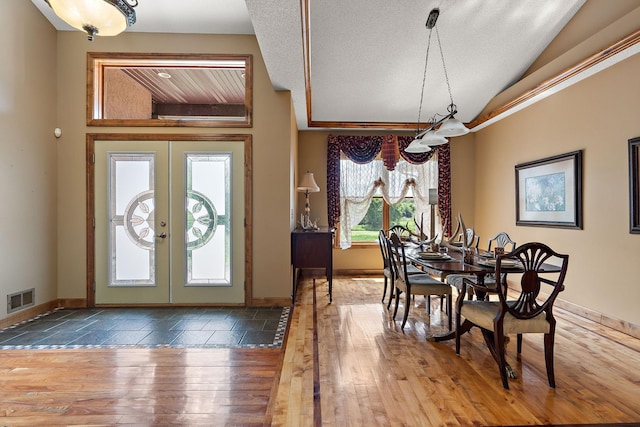 entryway featuring lofted ceiling, visible vents, baseboards, french doors, and hardwood / wood-style floors