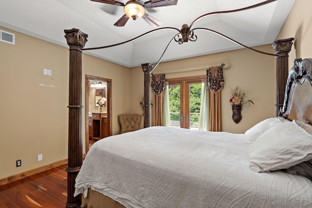 bedroom featuring baseboards, visible vents, ornate columns, and wood finished floors