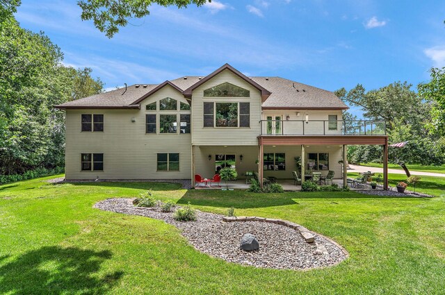 rear view of house featuring a patio and a yard