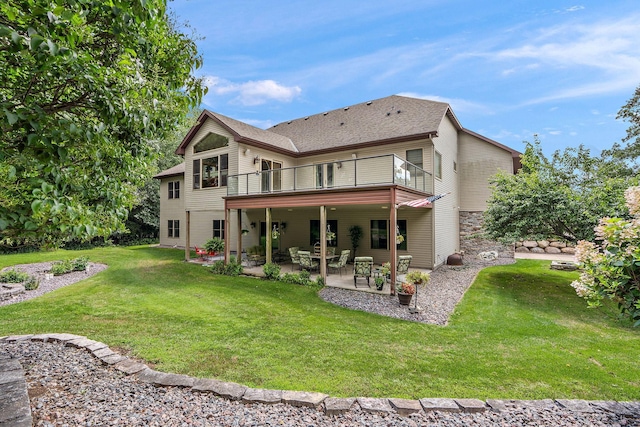 back of property with a patio area, a shingled roof, and a lawn