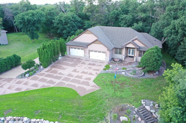 view of front of home featuring roof with shingles, a garage, stone siding, driveway, and a front lawn