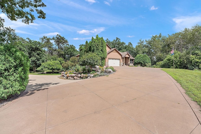 view of front facade with a garage, driveway, and stucco siding