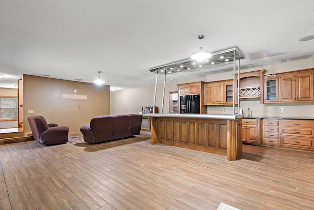 3126 137th Ave NE, Ham Lake, MN 55304 - kitchen featuring black fridge, open floor plan, light wood-style floors, brown cabinetry, and a center island