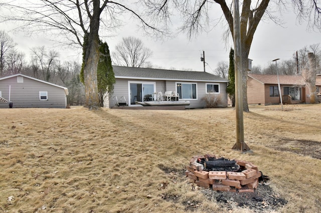 rear view of house featuring a fire pit and a shingled roof