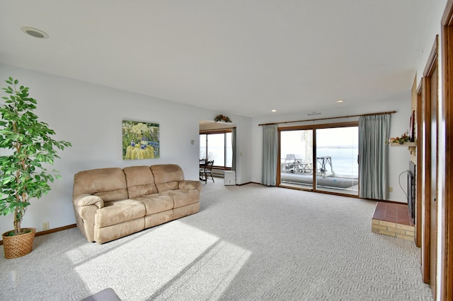 living room featuring recessed lighting, light colored carpet, and baseboards