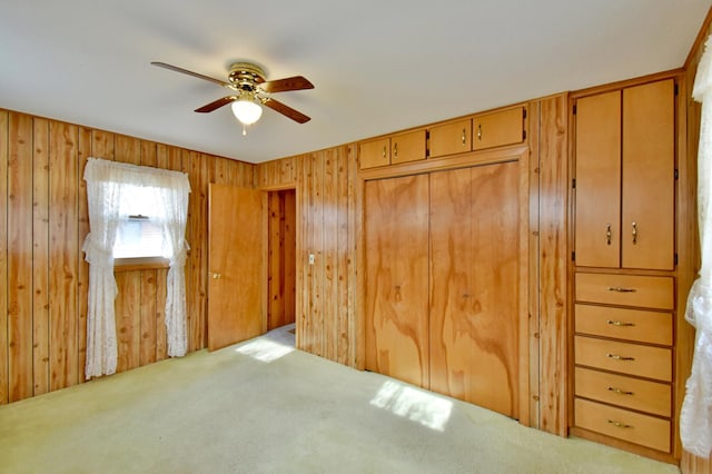 carpeted bedroom with wooden walls and ceiling fan