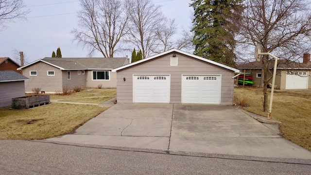 single story home featuring a detached garage and a front yard