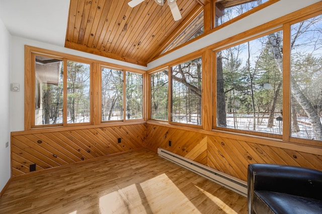 unfurnished sunroom with wood ceiling, a baseboard heating unit, vaulted ceiling, and a wealth of natural light