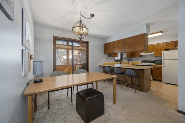 dining room featuring a chandelier, light floors, and a textured ceiling