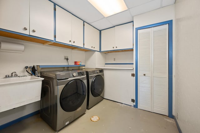 washroom featuring washer and dryer, cabinet space, and a sink