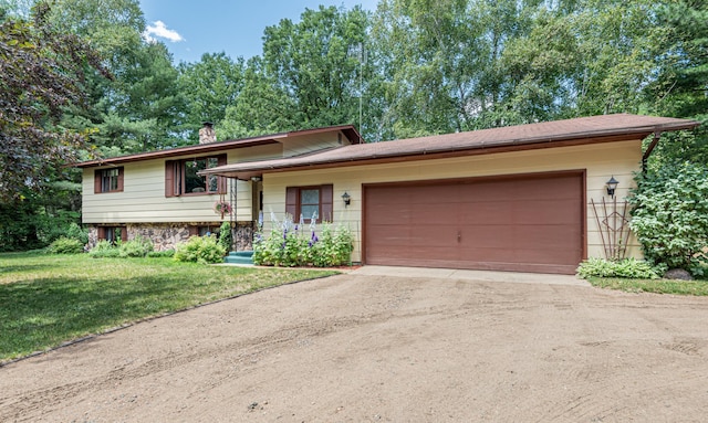 tri-level home featuring an attached garage, driveway, a chimney, and a front lawn