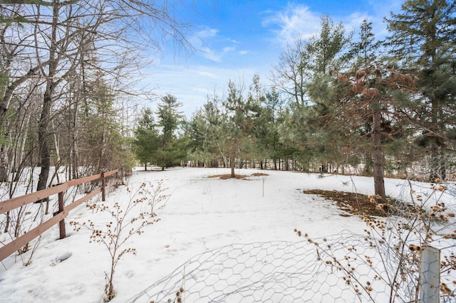 snowy yard featuring fence