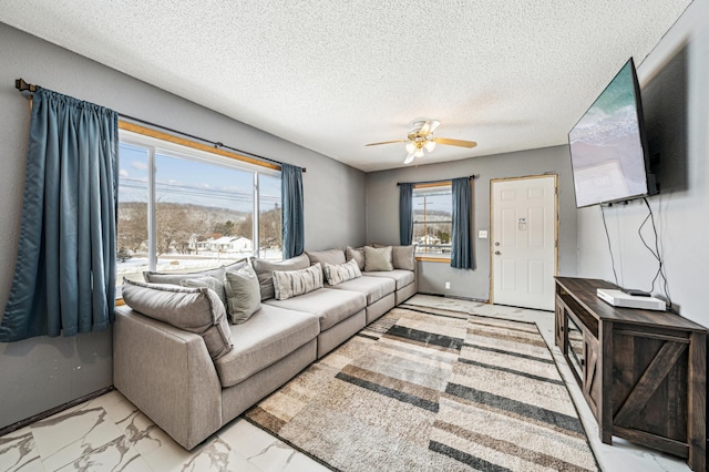 living room featuring a textured ceiling, marble finish floor, and a ceiling fan