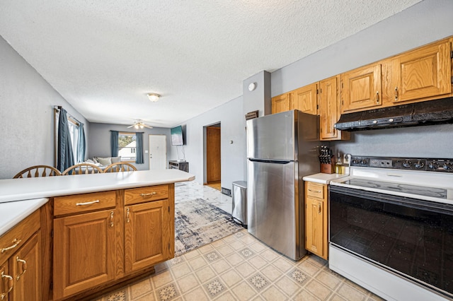 kitchen featuring freestanding refrigerator, ceiling fan, light countertops, electric stove, and under cabinet range hood