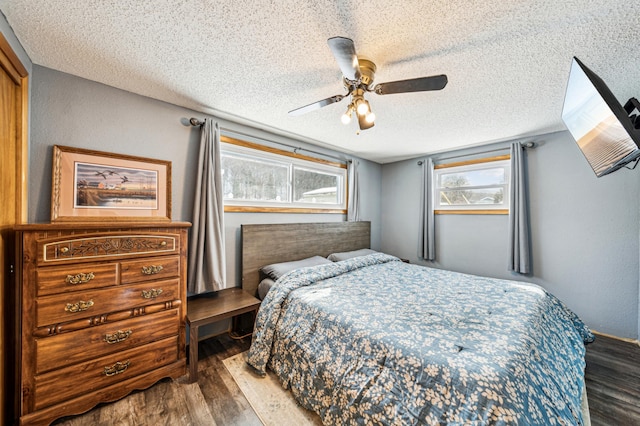 bedroom featuring a ceiling fan, wood finished floors, and a textured ceiling