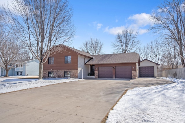 view of front of home featuring fence, an attached garage, a shingled roof, concrete driveway, and brick siding