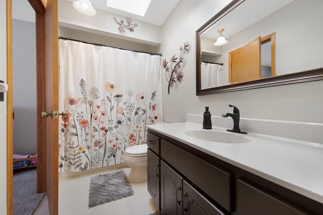 full bathroom featuring vanity, a skylight, toilet, and tile patterned flooring