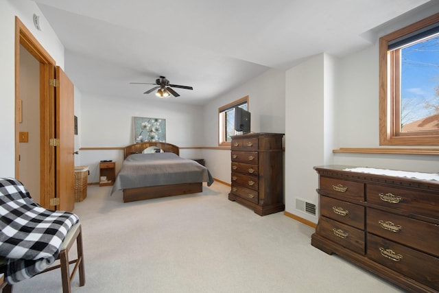 bedroom with light carpet, visible vents, ceiling fan, and baseboards